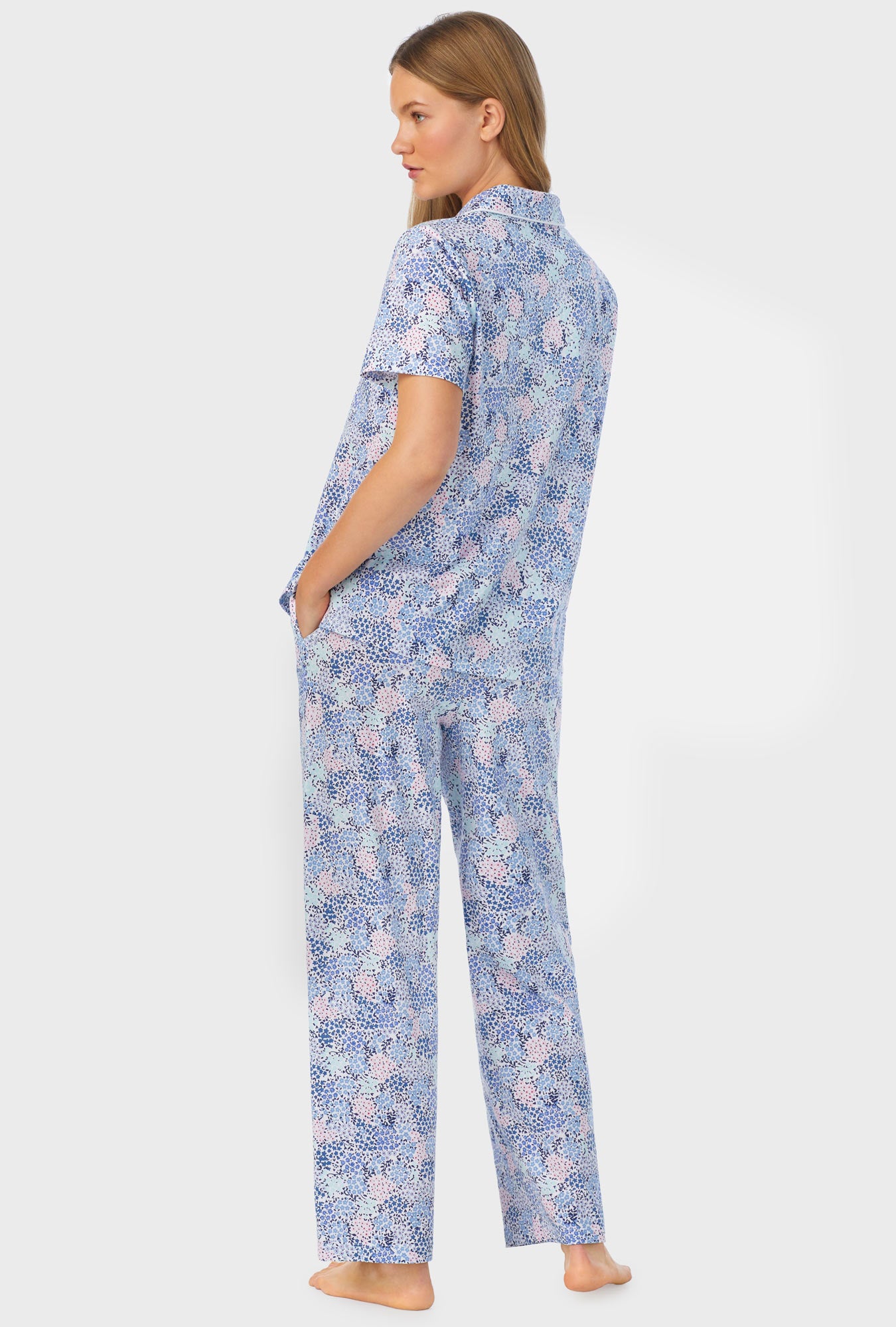 A lady wearing a short sleeve long pajama set with midnight dream print.