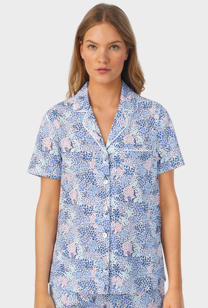 A lady wearing a short sleeve long pajama set with midnight dream print.