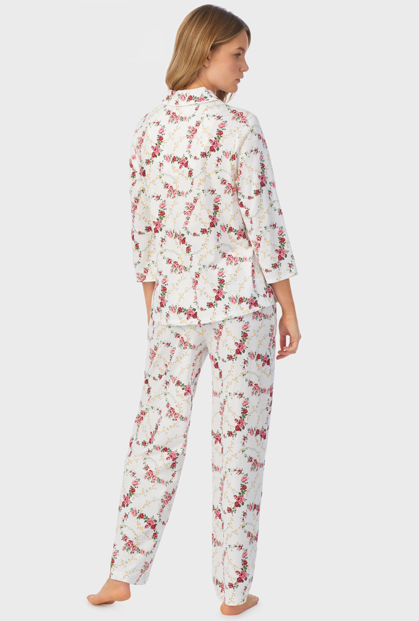 A lady wearing long sleeve long pajama set with rose vine print.