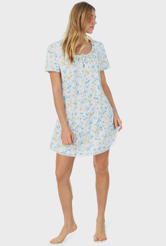 A lady wearing white short sleeve short nightgown with breeze blooms.