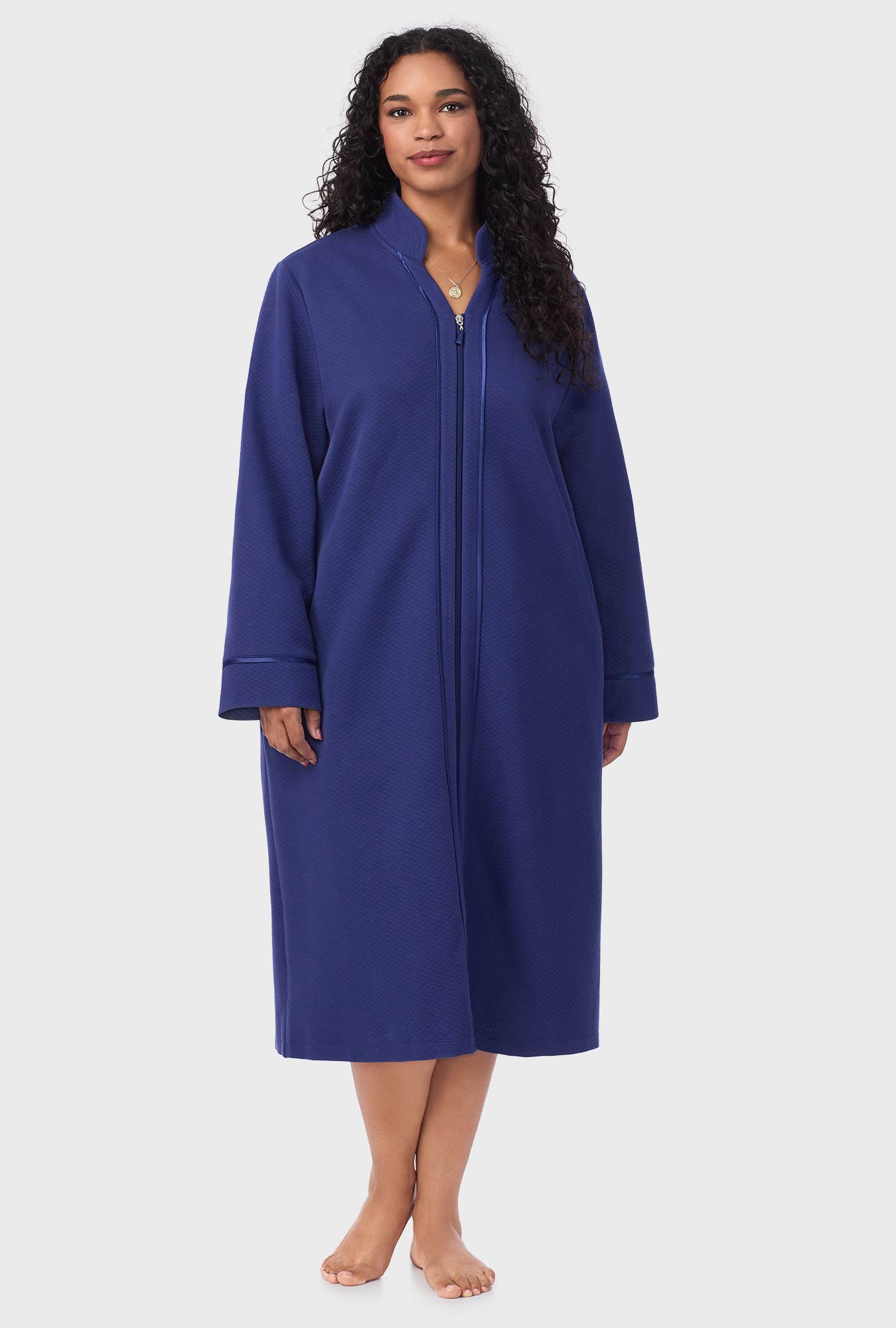 A lady wearing navy long sleeve diamond quilted plus zip robe.