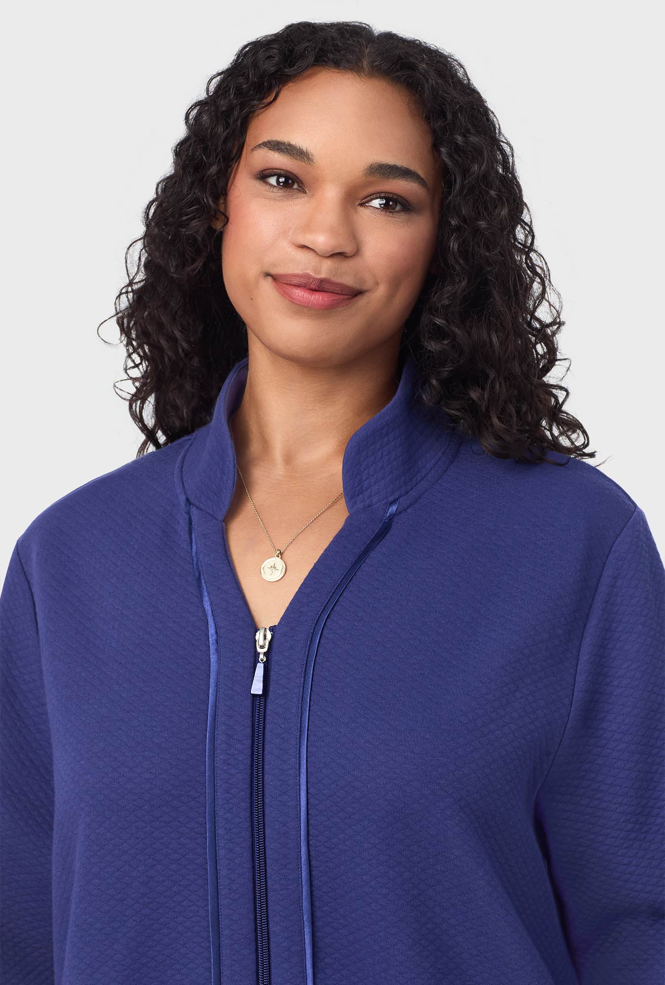 A lady wearing navy long sleeve diamond quilted plus zip robe.