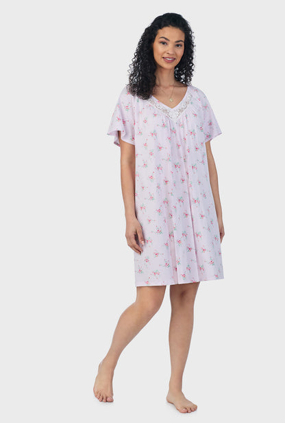 A lady wearing pink short sleeve cotton short plus size nightgown with sweet blooms print.