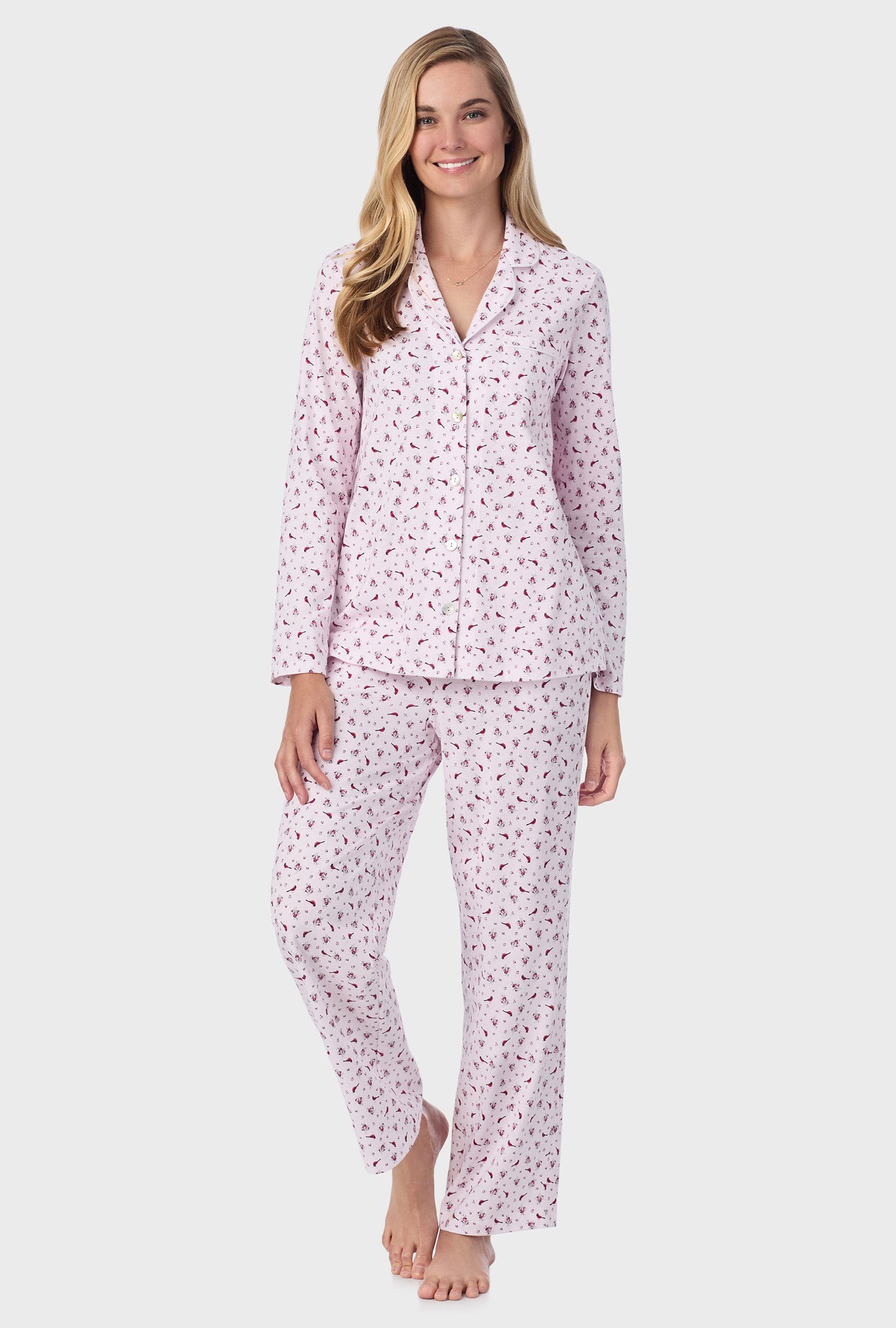 A lady wearing pink long sleeve cotton long pajama set with mini cardinal print.