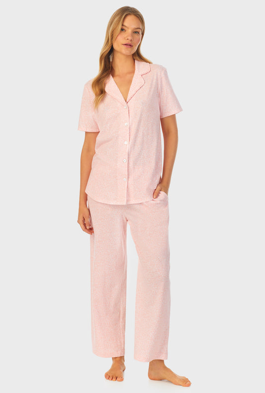 A lady wearing orange short sleeve Capri Pajama Set with Floral Vine print