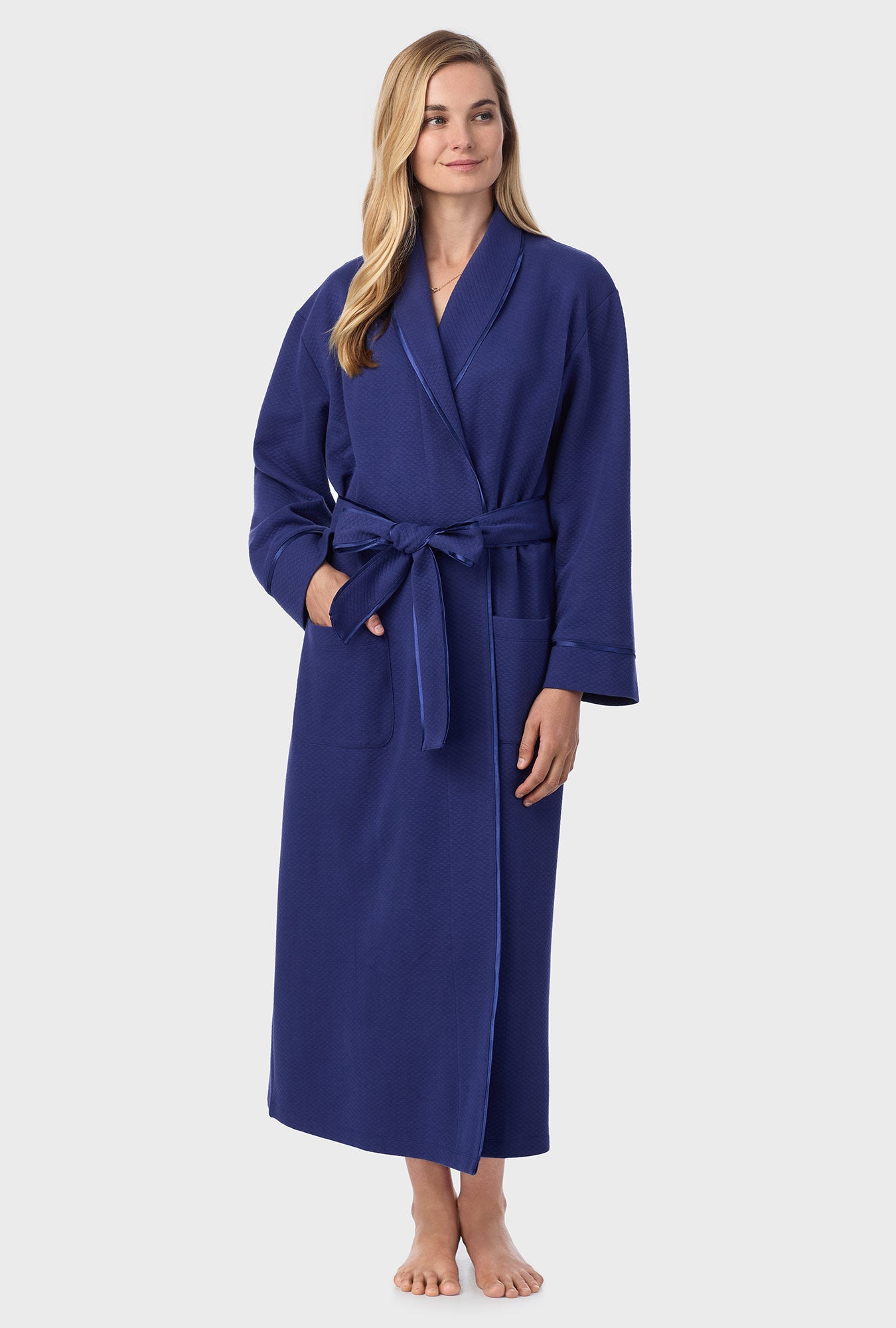 A lady wearing navy long sleeve diamond quilted wrap robe.