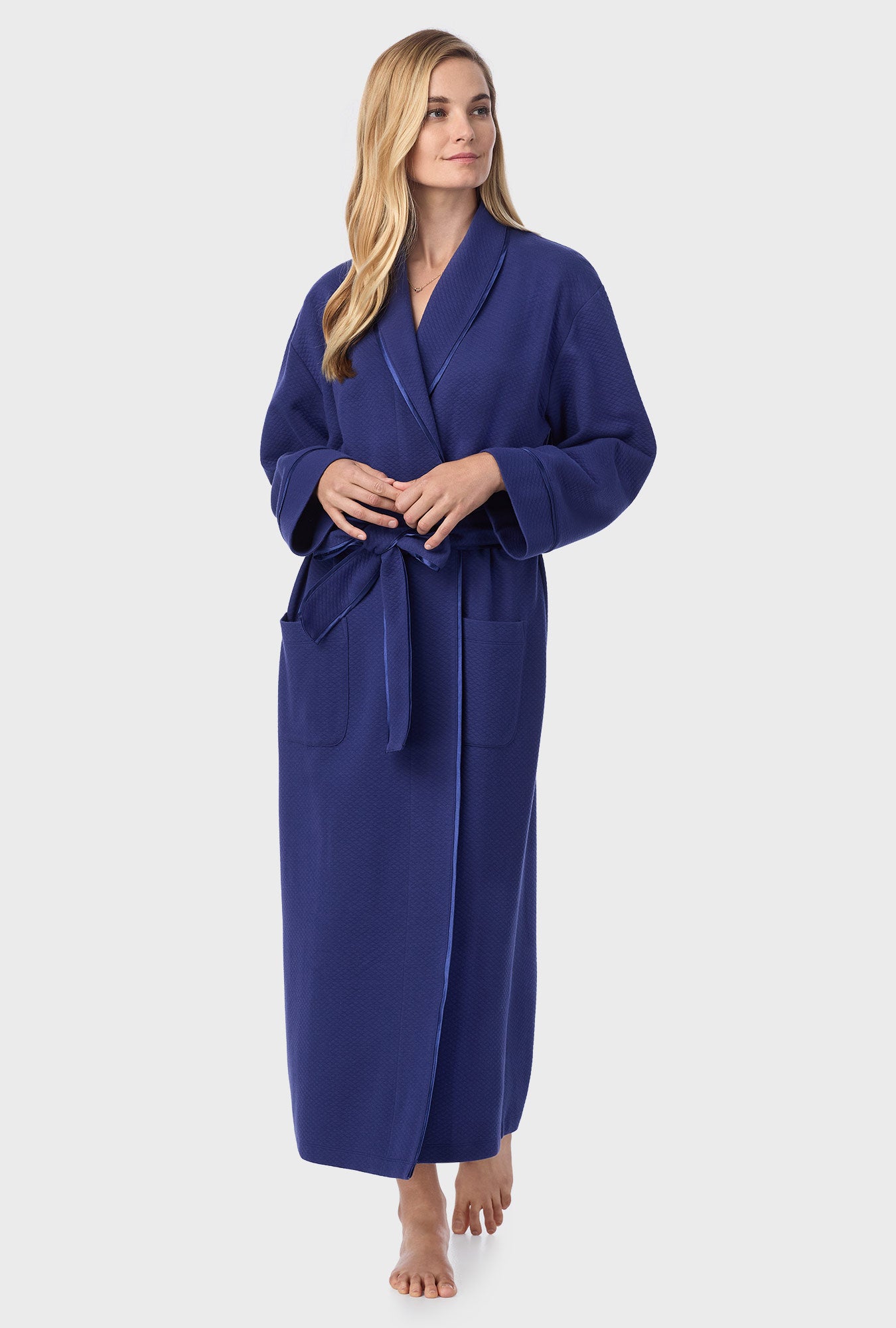 A lady wearing navy long sleeve diamond quilted wrap robe.