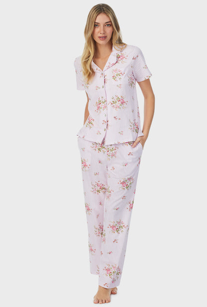 A lady wearing pink short sleeve long petite pajama set with fleur print