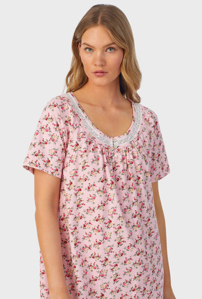 A lady wearing short sleeve nightshirt with wild blooms print.