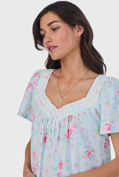 A lady wearing blue short Sleeve Cotton Waltz Nightgown with French Garden print.