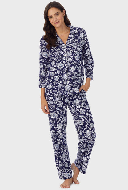 A lady wearing navy long sleeve long pajama set with white floral print