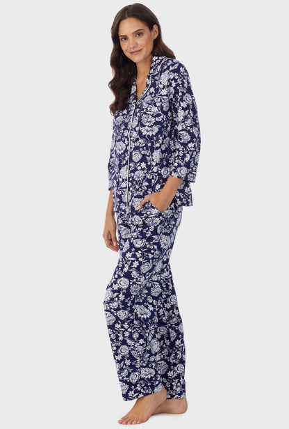 A lady wearing navy long sleeve long pajama set with white floral print