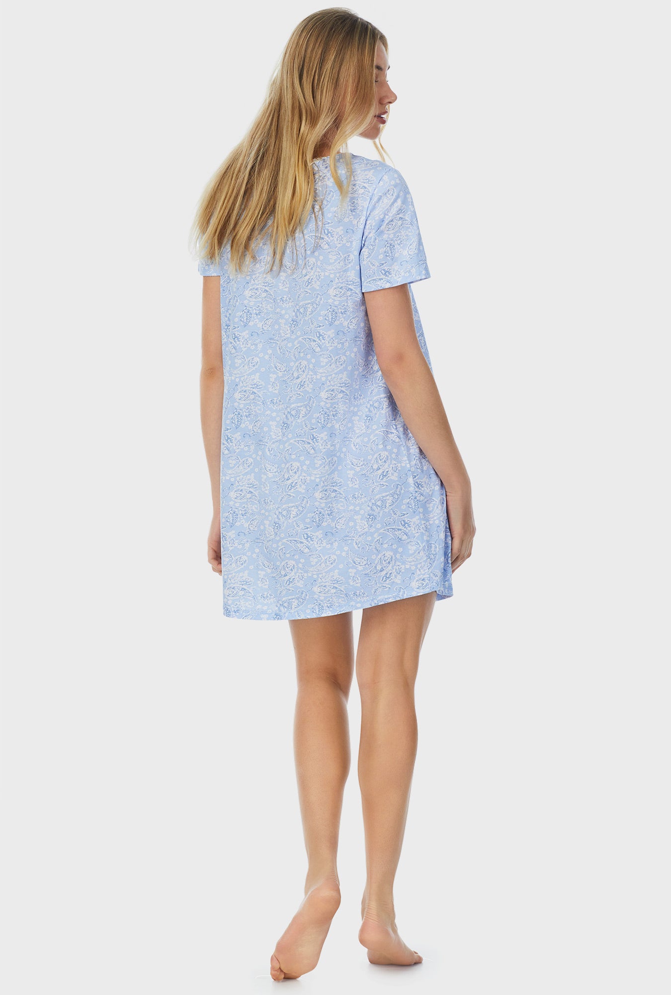 A lady wearing blue short sleeve short nightgown with blooming paisley print.