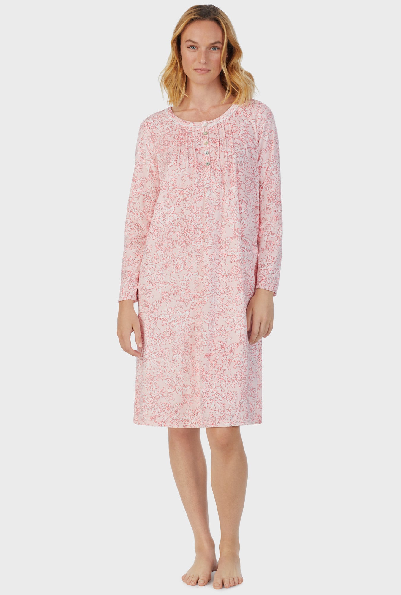 A lady wearing pink long sleeve fleece floral scroll nightgown.