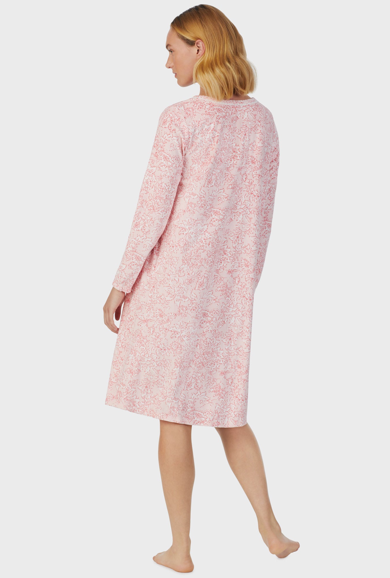 A lady wearing pink long sleeve fleece floral scroll nightgown.