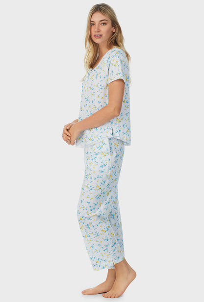A lady wearing white short sleeve capri pajama set with breeze blooms.