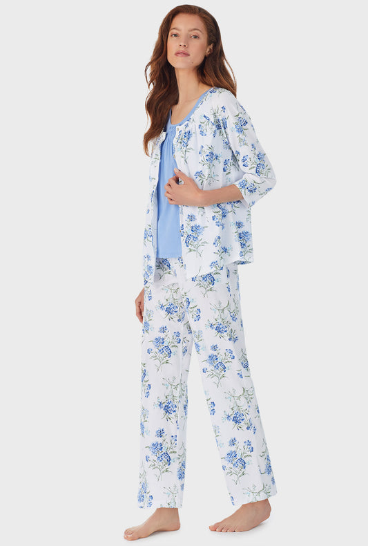 A lady wearing white long 3 piece pajama set with blue floral print