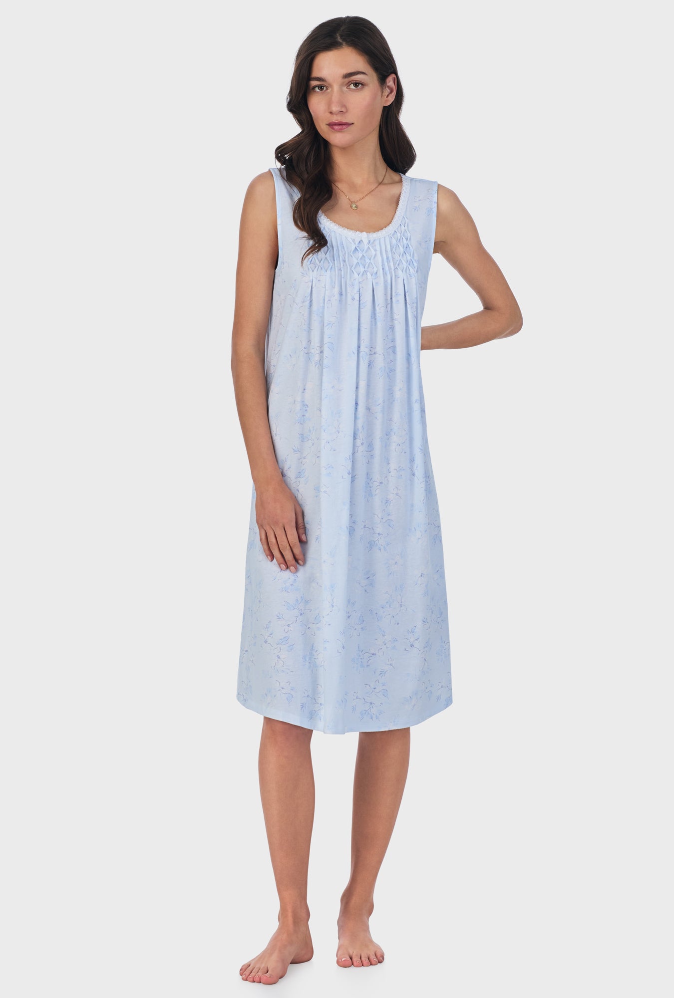 A lady wearing blue sleeveless cotton waltz nightgown with summer magnolia print.