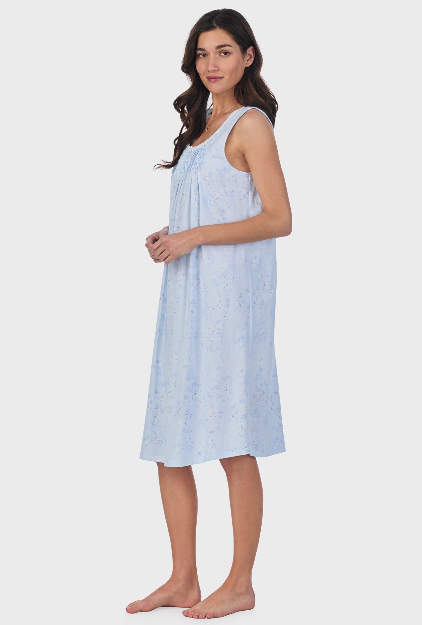 A lady wearing blue sleeveless cotton waltz nightgown with summer magnolia print.