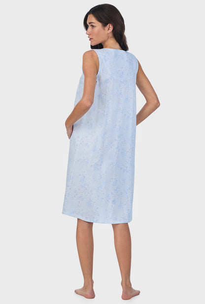 A lady wearing blue sleeveless cotton waltz nightgown with summer magnolia print.