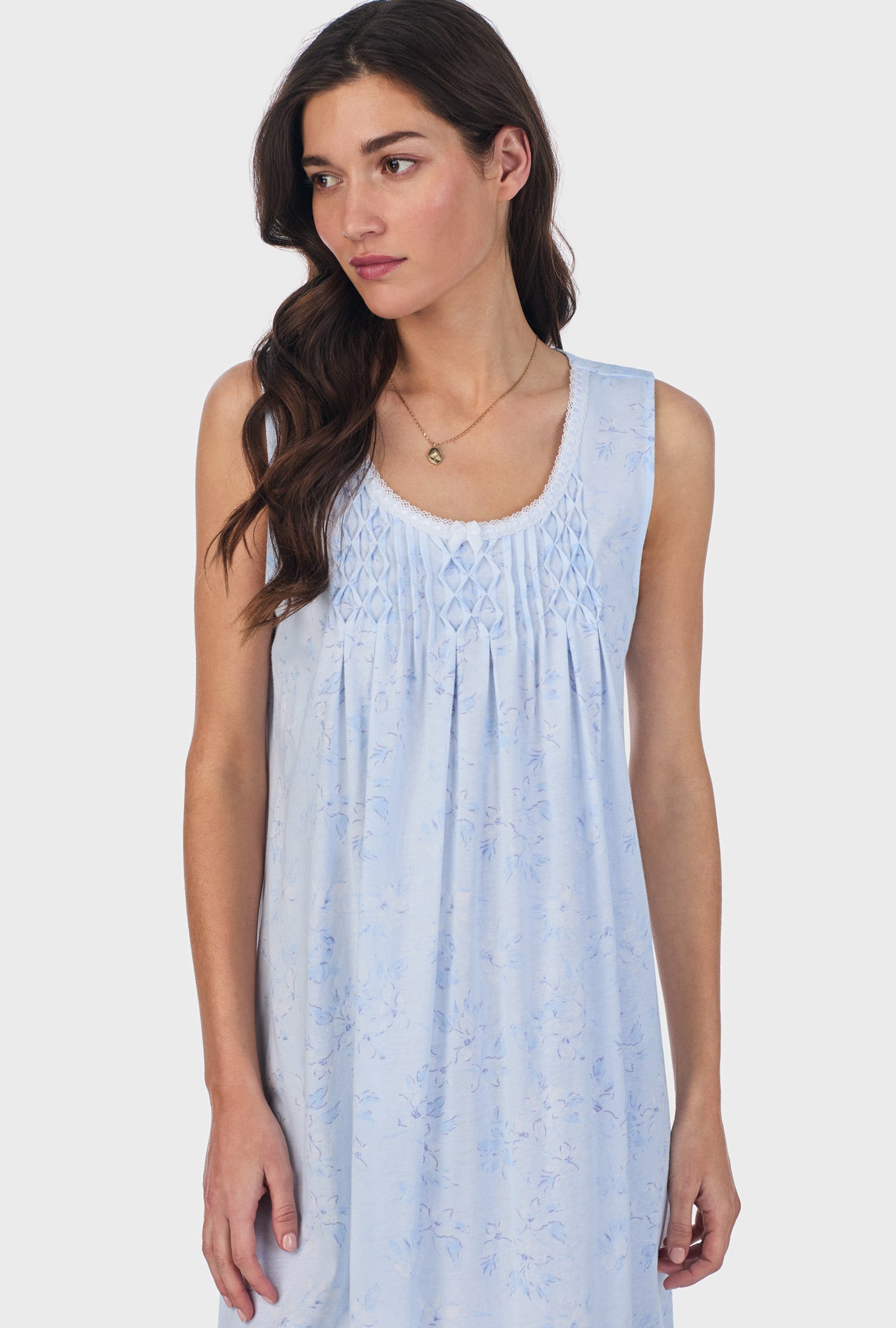 A lady wearing blue sleeveless cotton waltz nightgown with summer magnolia print.