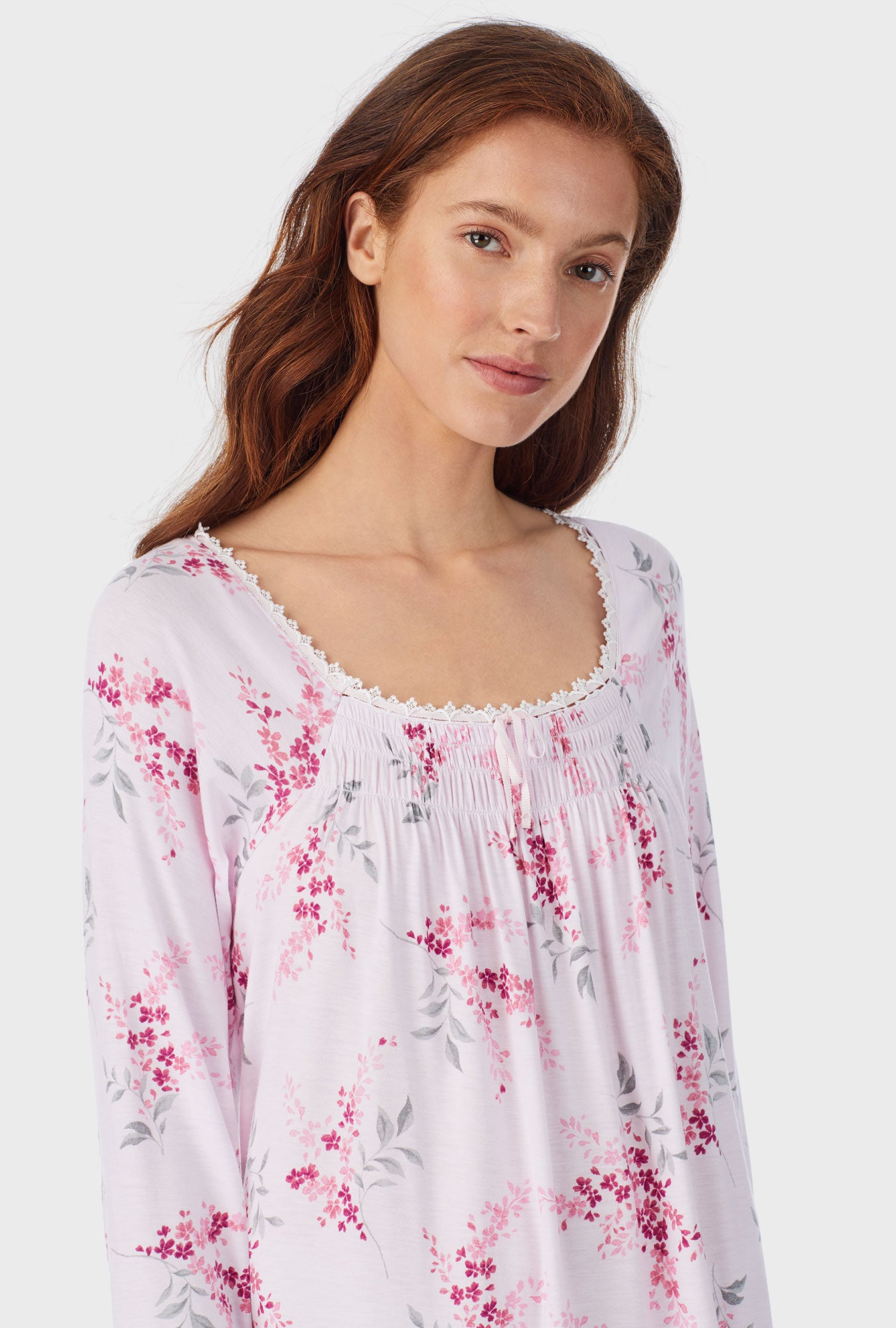 A lady wearing white waltz nightgown with pink floral print