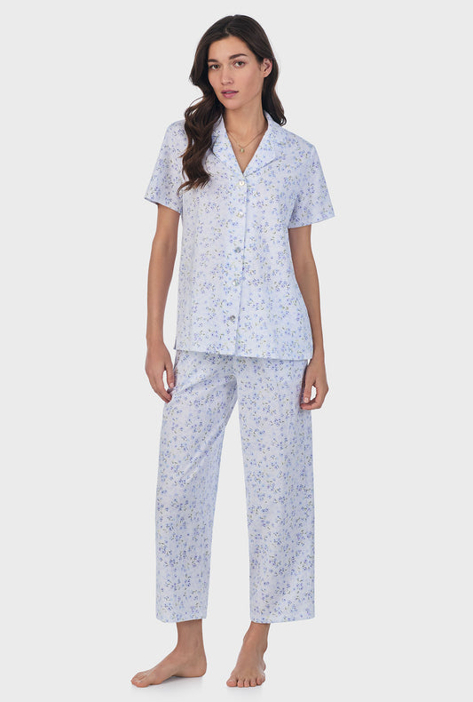 A lady wearing blue short sleeve cotton capri pajama set with blue freesia print.