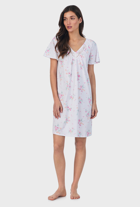 A lady wearing pink short sleeve cotton short nightgown with floral bouquet print.