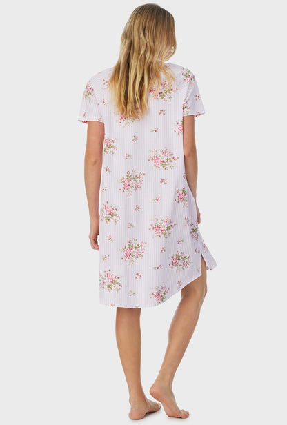 A lady wearing pink short sleeve petite waltz nightgown with fleur print