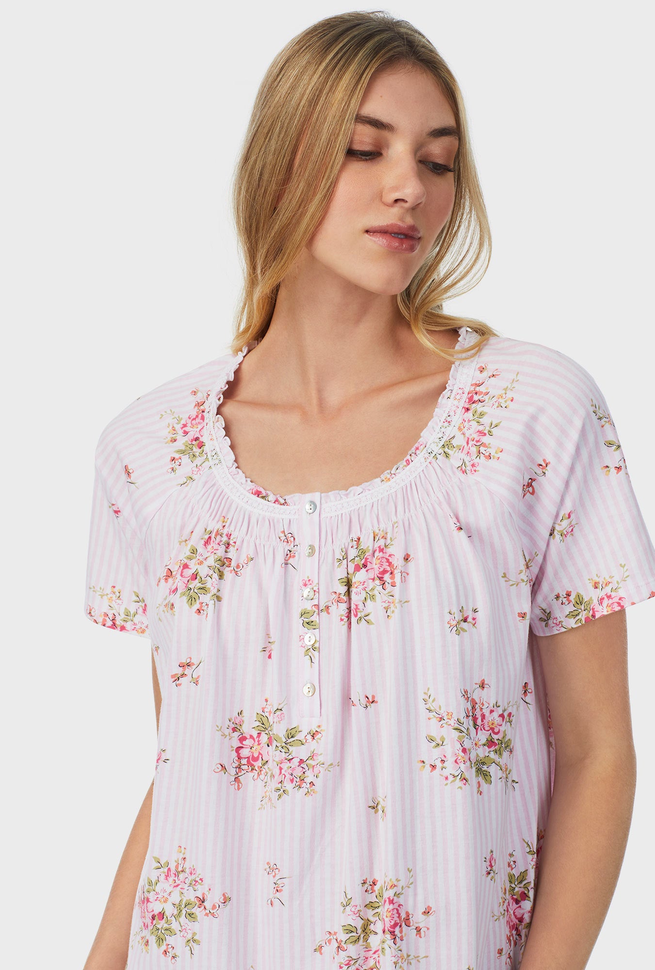 A lady wearing pink short sleeve petite waltz nightgown with fleur print
