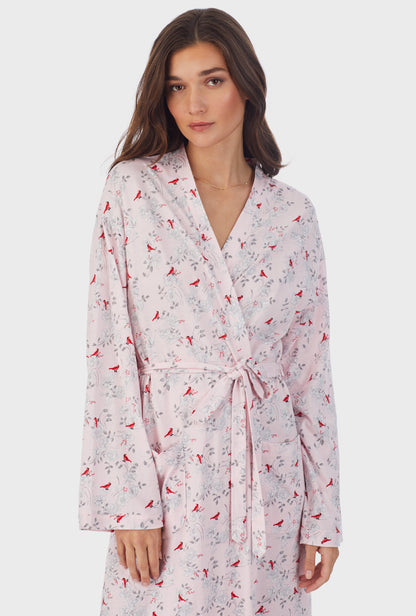 A lady wearing pink long sleeve cotton jersey wrap robe with cardinal print.