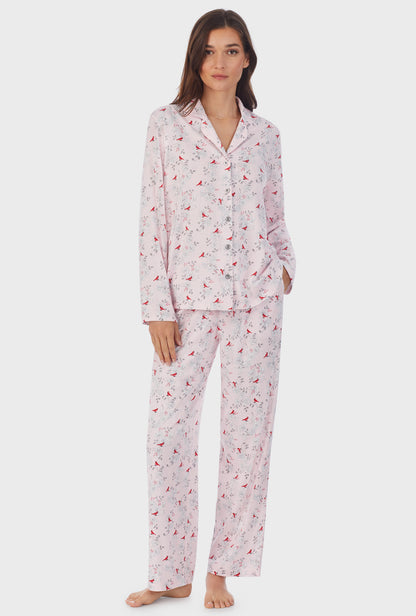 A lady wearing pink long sleeve long cardinal pajama set.