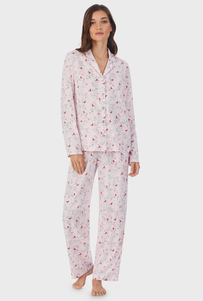 A lady wearing pink long sleeve long cardinal pajama set.