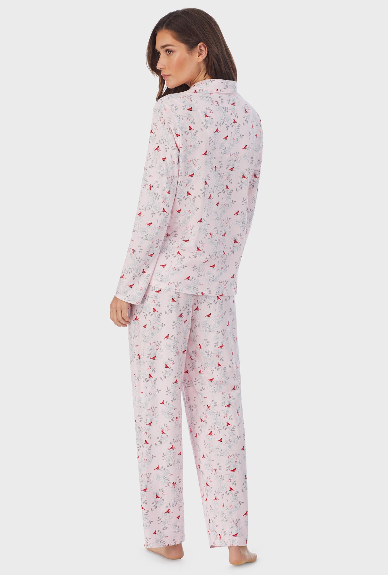 A lady wearing pink long sleeve long cardinal pajama set.