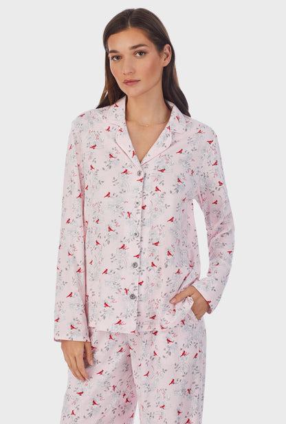 A lady wearing pink long sleeve long cardinal pajama set.