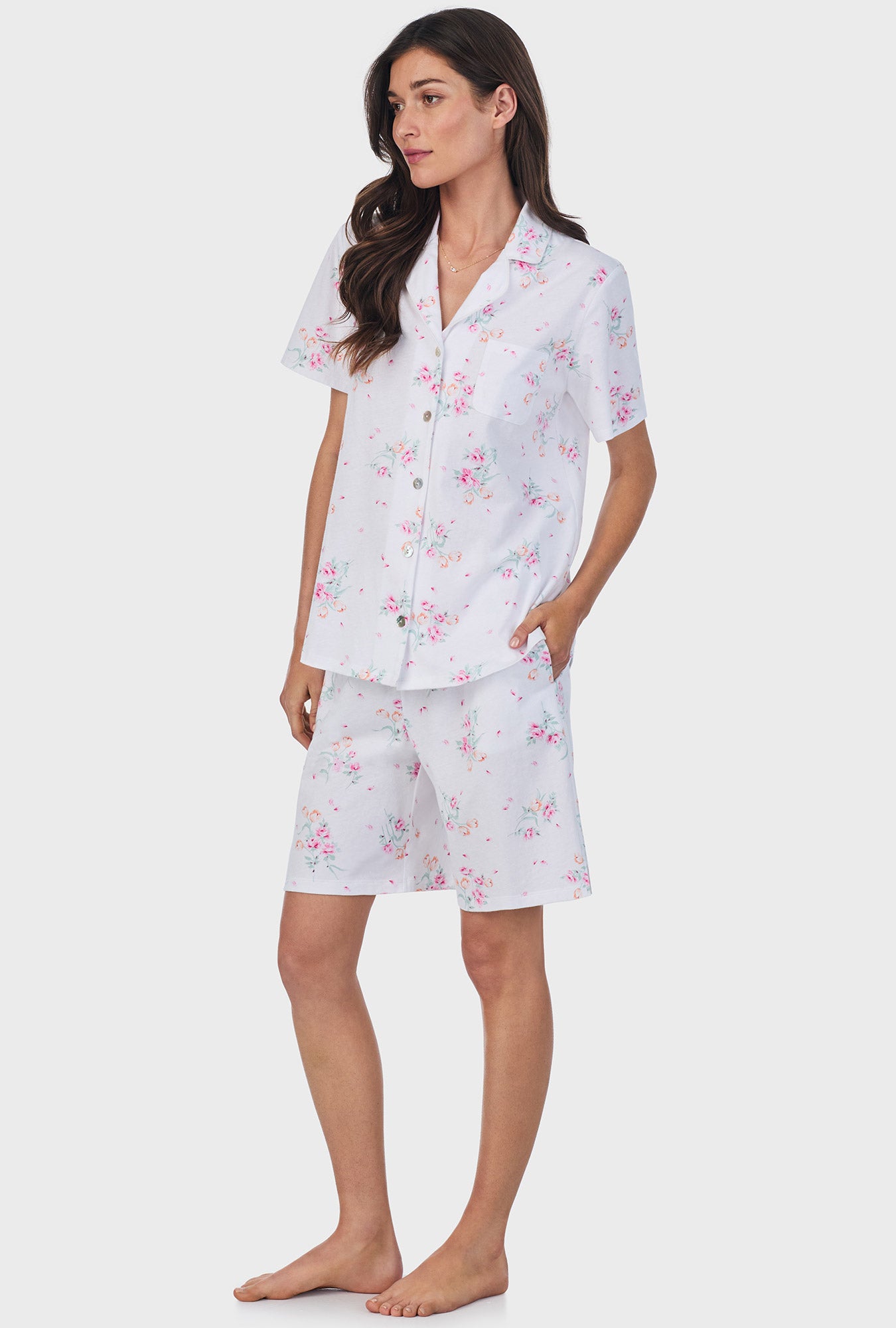 A lady wearing pink short sleeve cotton bermuda pajama set with floral bouquet print.