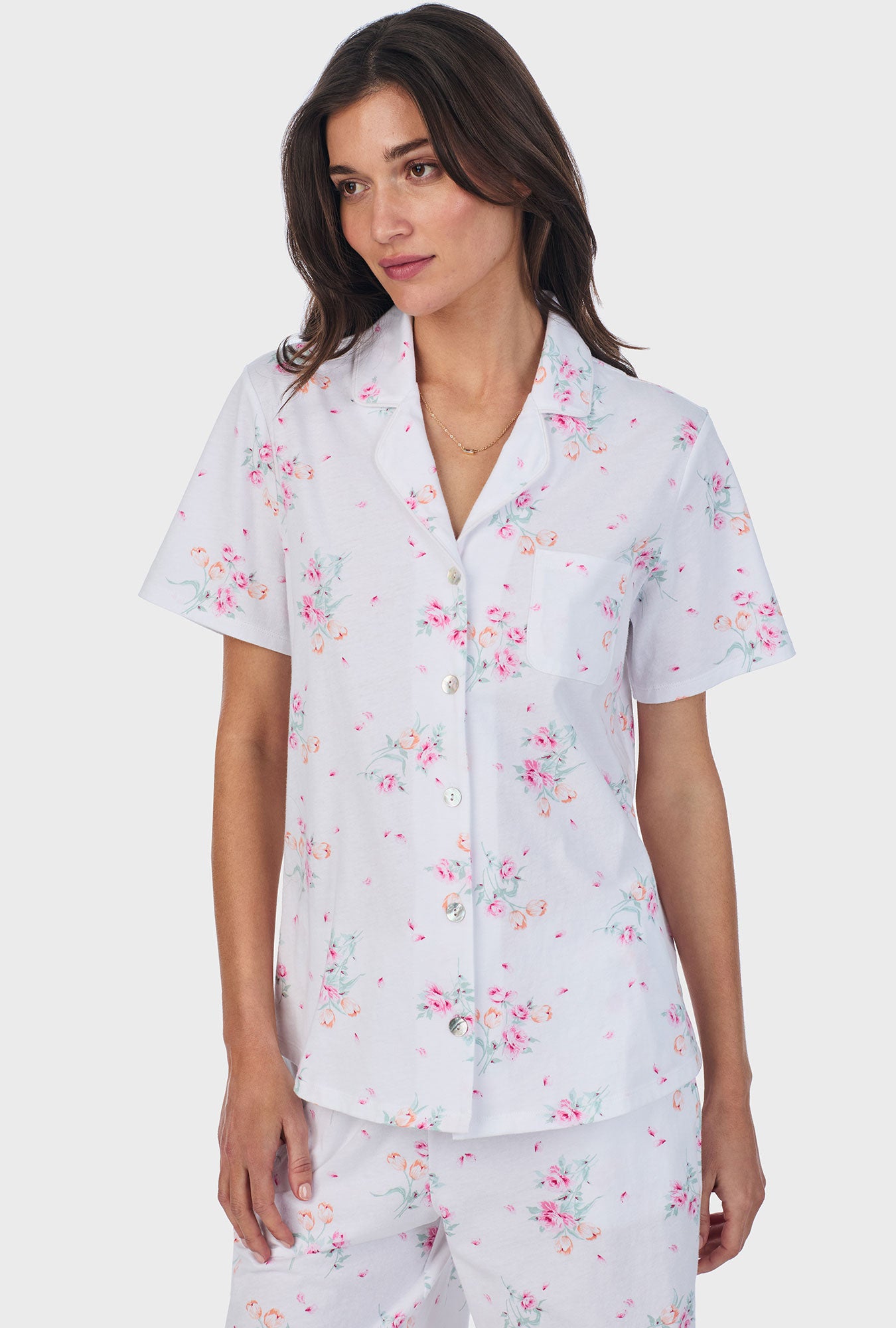 A lady wearing pink short sleeve cotton bermuda pajama set with floral bouquet print.