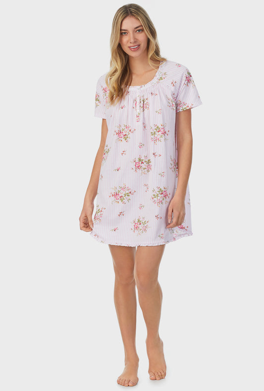 A lady wearing pink short sleeve petite short nightshirt with fleur print