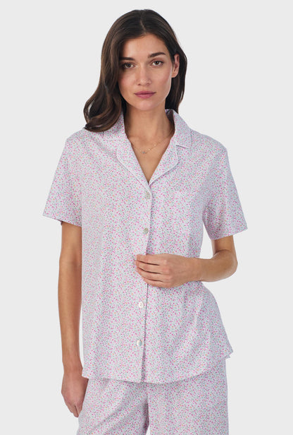 A lady wearing pink short sleeve cotton capri pajama set with tulip field print.