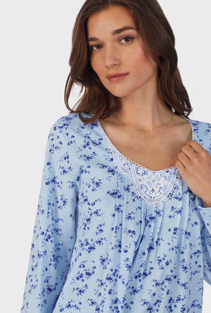 A lady wearing blue long sleeve cotton long pajama set with winter floral print.