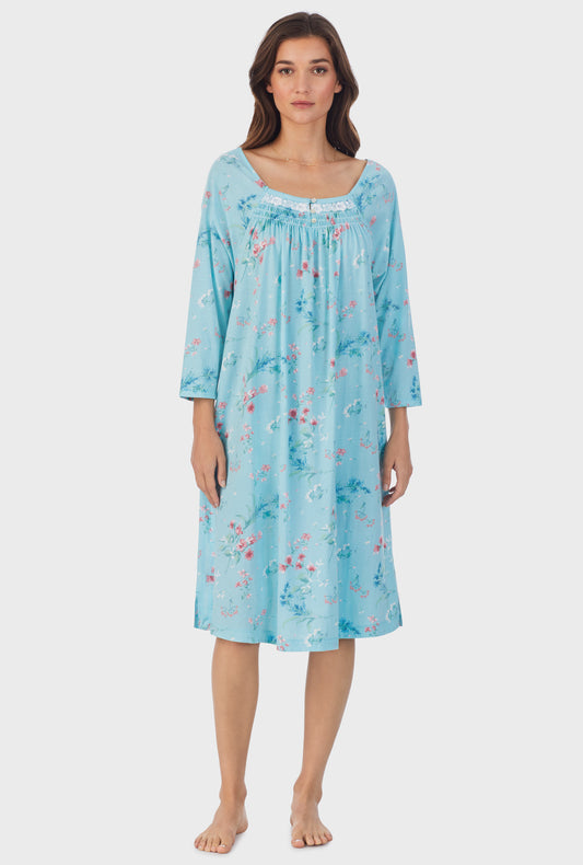 A lady wearing blue long sleeve cotton waltz nightgown with aqua floral print.