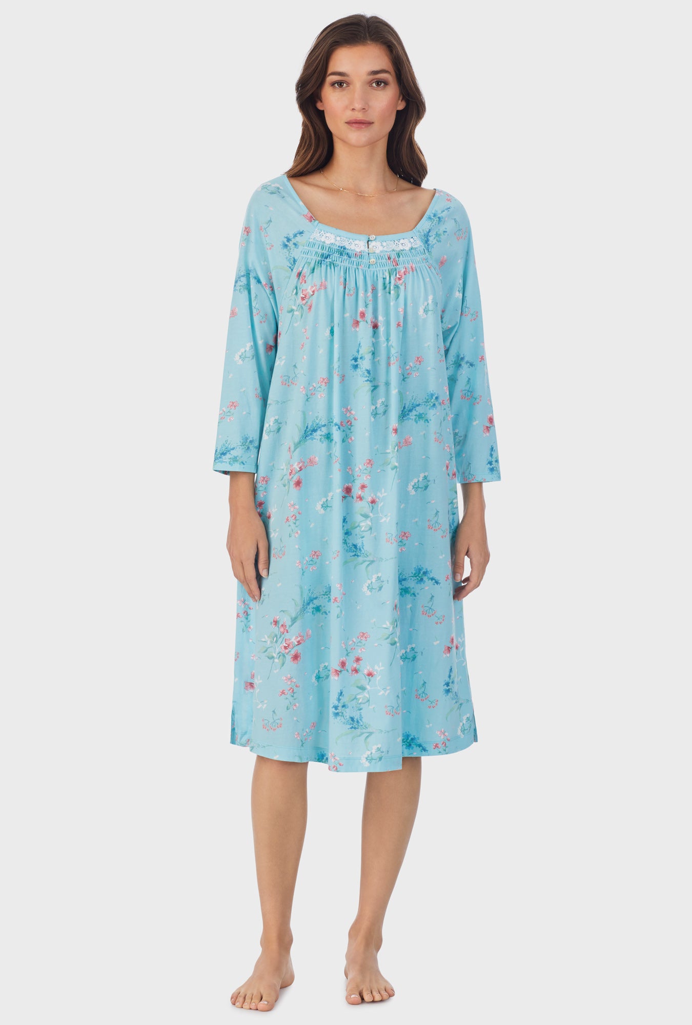 A lady wearing blue long sleeve cotton waltz nightgown with aqua floral print.