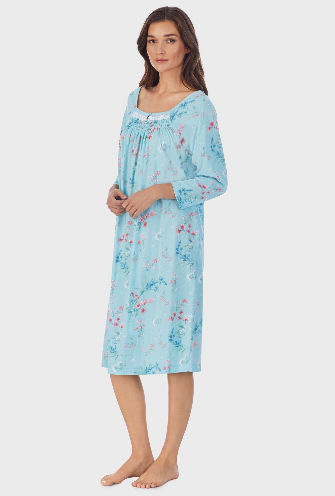 A lady wearing blue long sleeve cotton waltz nightgown with aqua floral print.