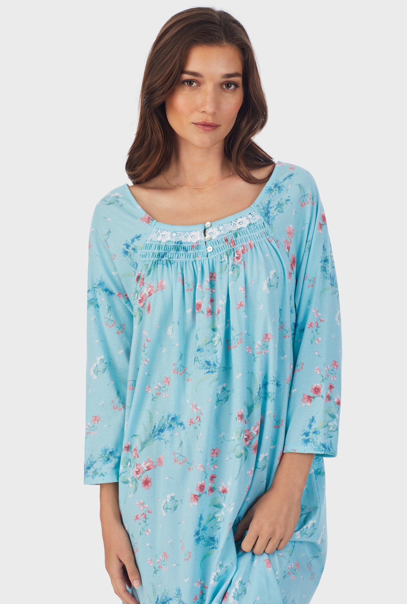 A lady wearing blue long sleeve cotton waltz nightgown with aqua floral print.