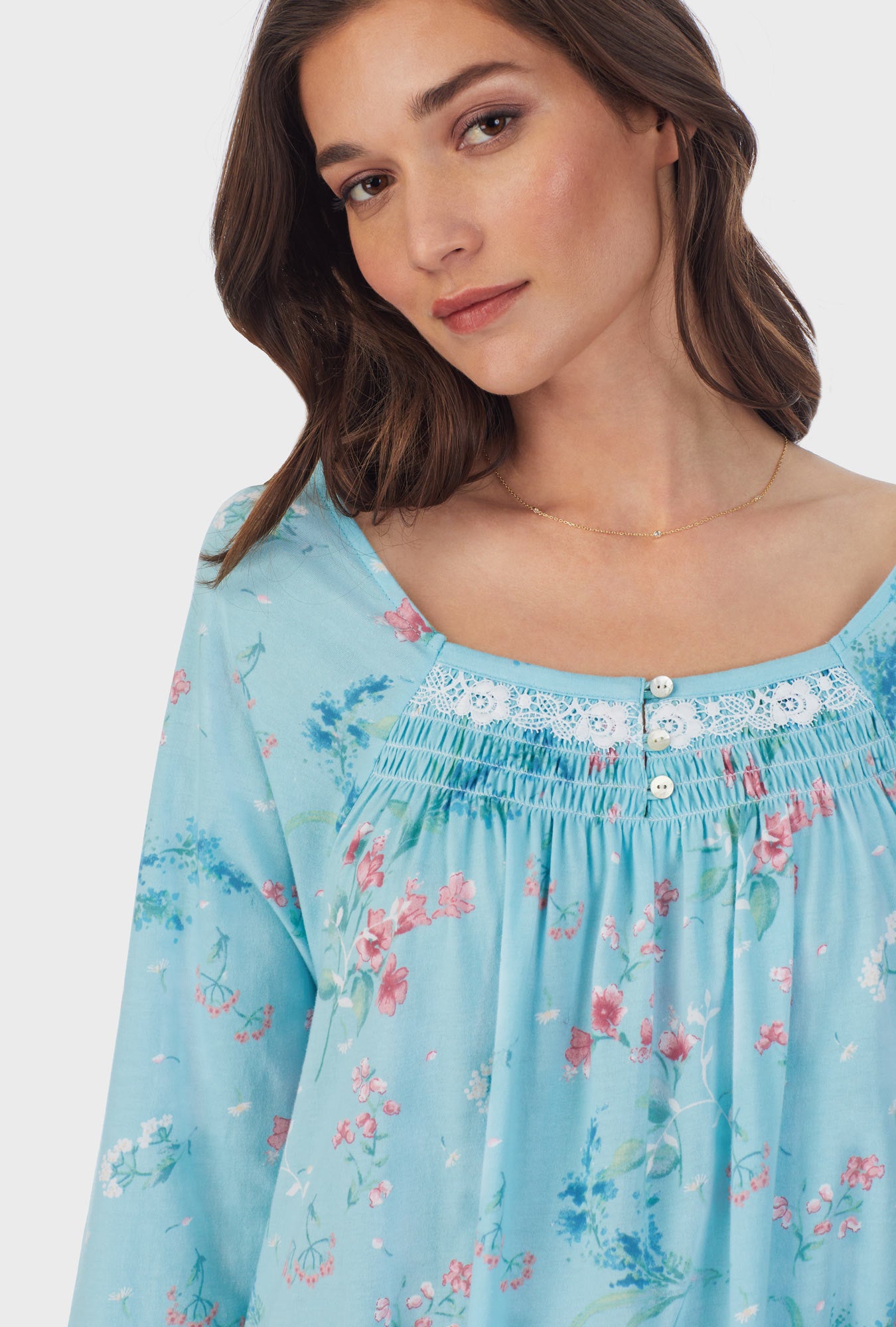 A lady wearing blue long sleeve cotton waltz nightgown with aqua floral print.