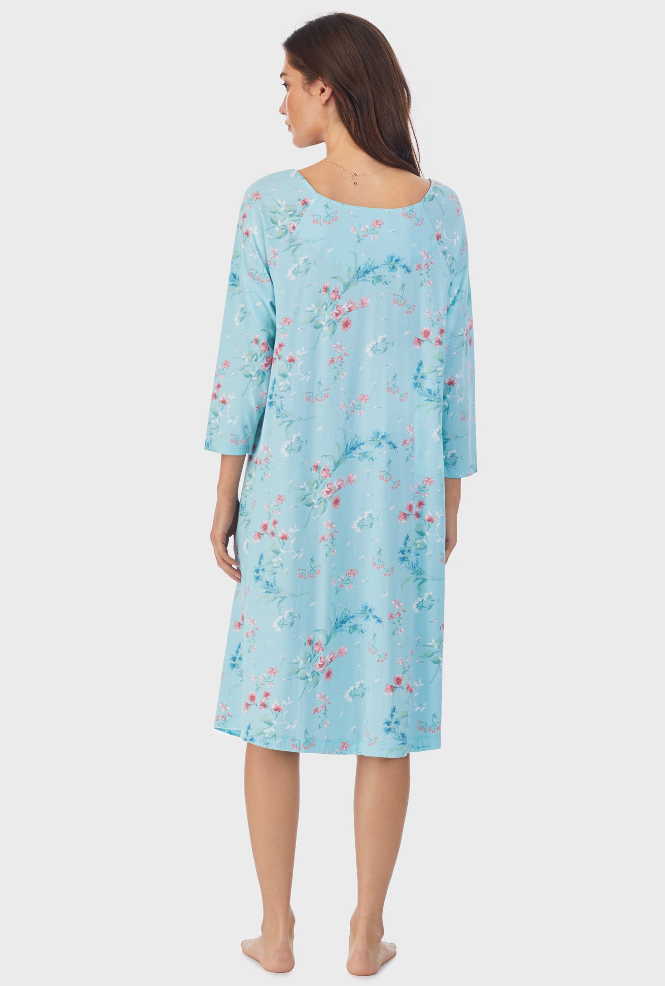 A lady wearing blue long sleeve cotton waltz nightgown with aqua floral print.