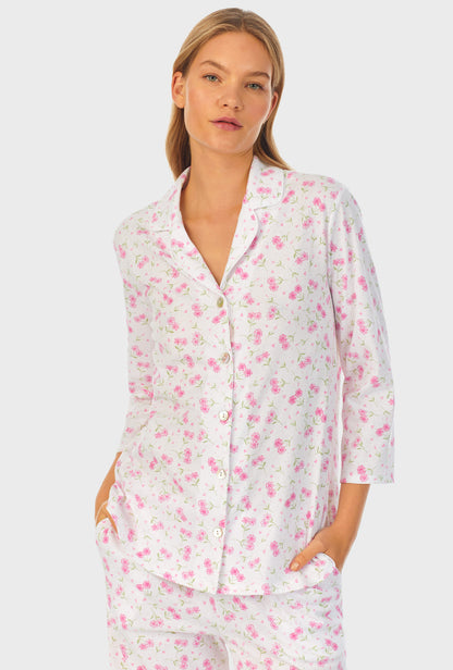 A lady wearing white quarter sleeve cotton long pajama set with blooming heart print.