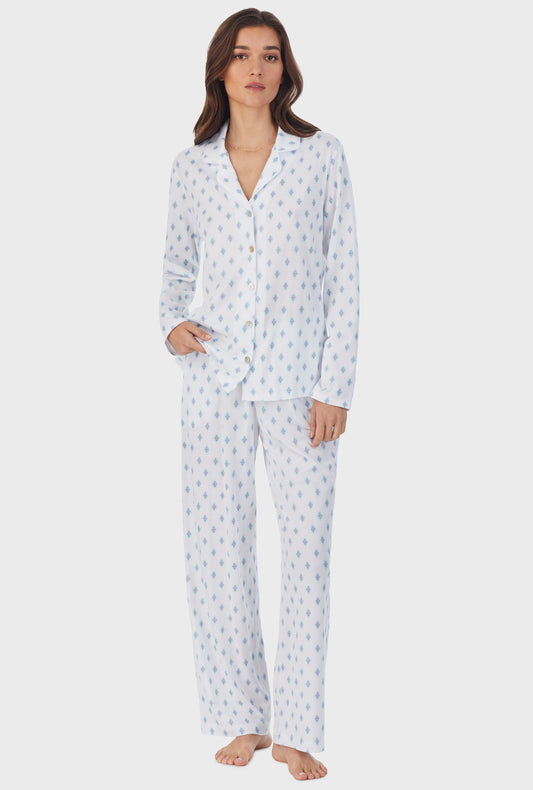 A lady wearing white long pajama set with aqua geo