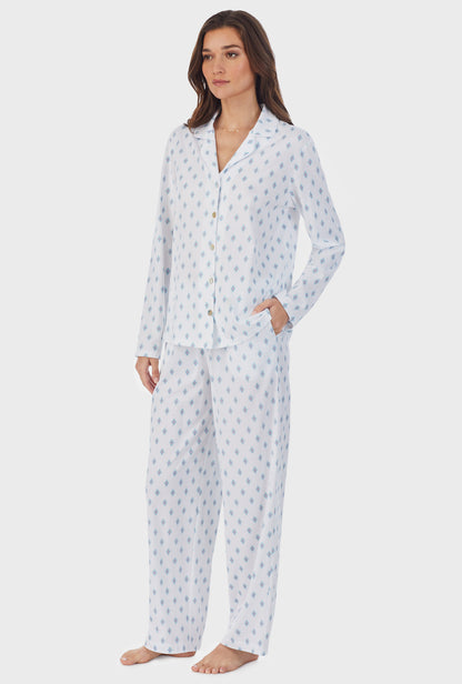 A lady wearing white long pajama set with aqua geo