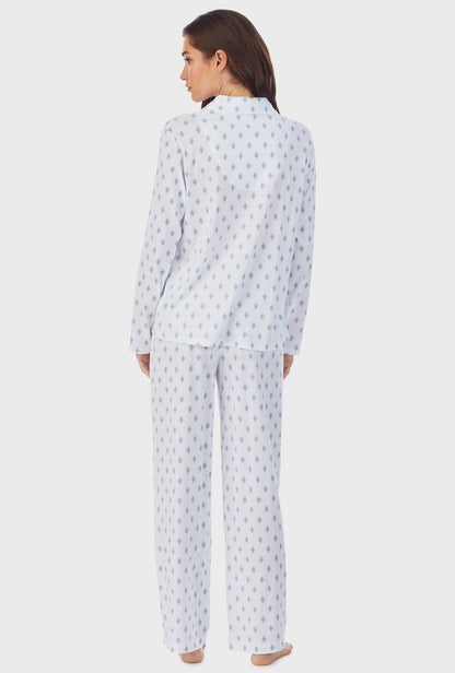 A lady wearing white long pajama set with aqua geo